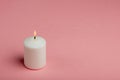 One whiteÃÂ burningÃÂ candle onÃÂ pink backgroundÃÂ withÃÂ copyÃÂ space forÃÂ text Royalty Free Stock Photo